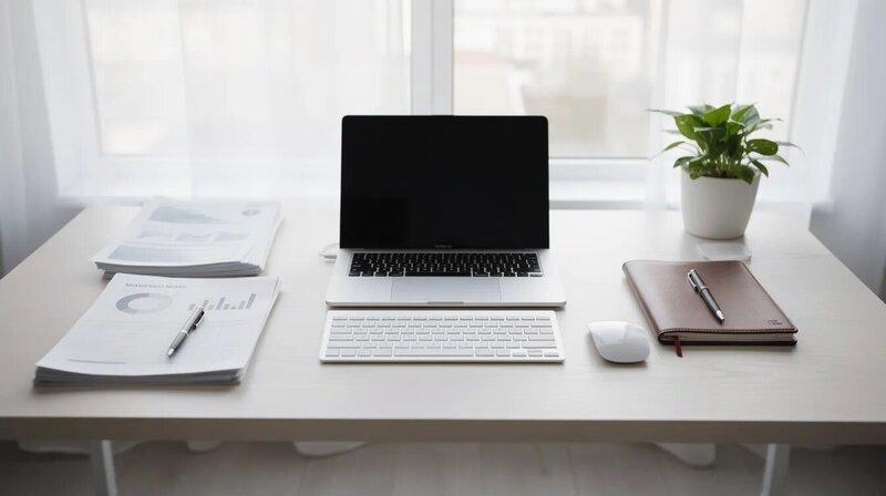 Une image d'un bureau bien organisé, comprenant un ordinateur portable ouvert et des documents professionnels soigneusement disposés. Cet espace de travail évoque une ambiance propice à la rédaction d'une lettre de motivation pour une candidature spontanée, avec des éléments essentiels pour réussir dans le marché du travail.